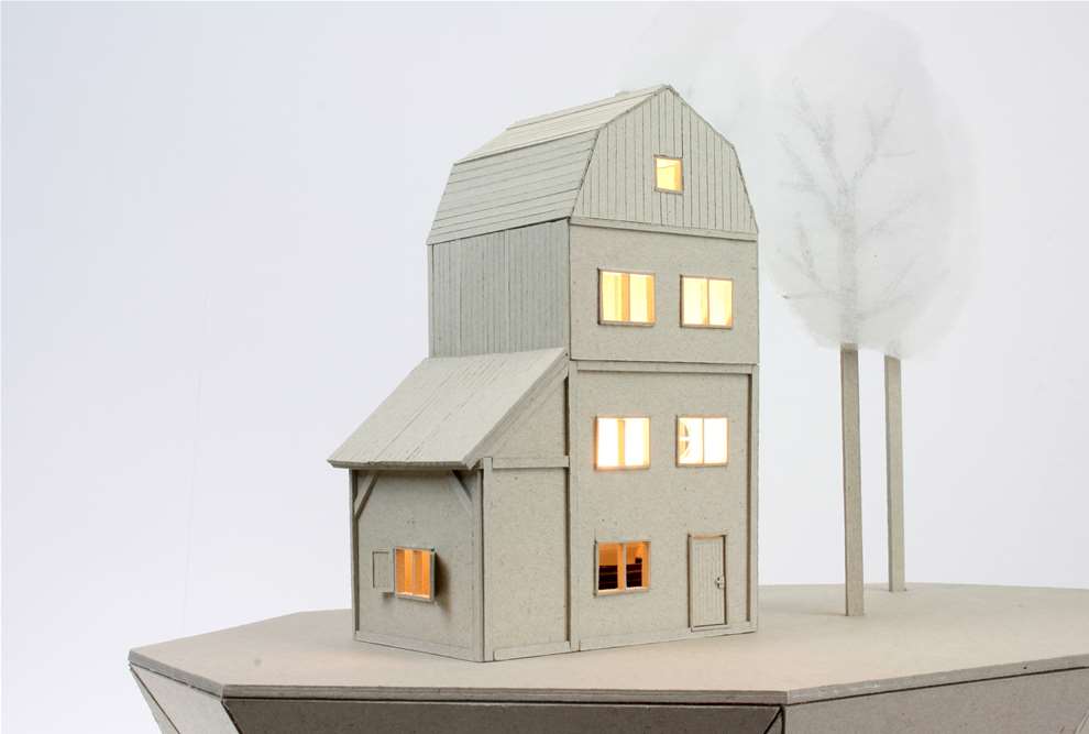 Vera Van Wolferen, Crafted intricate cardboard sculpture of a floating house with lights on.