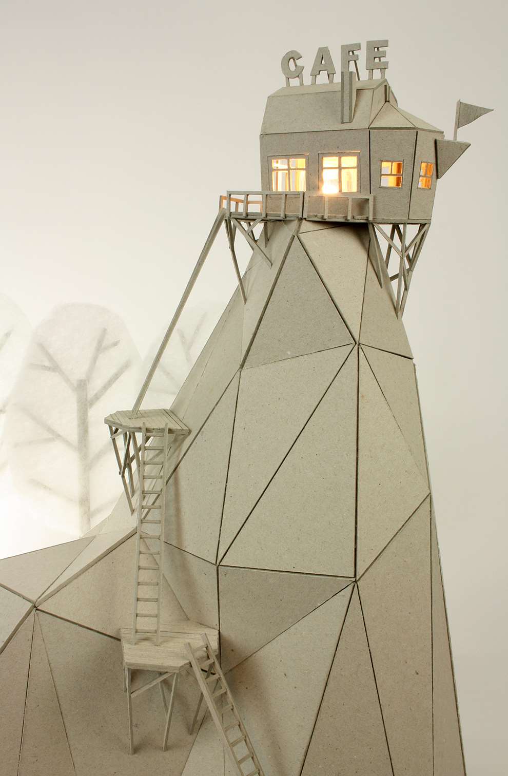 Vera Van Wolferen, Crafted intricate paper and balsa wood sculpture of a  cafe at the top of a Rocky Mountain, with trees in the background. Crafted Magical miniature universe.