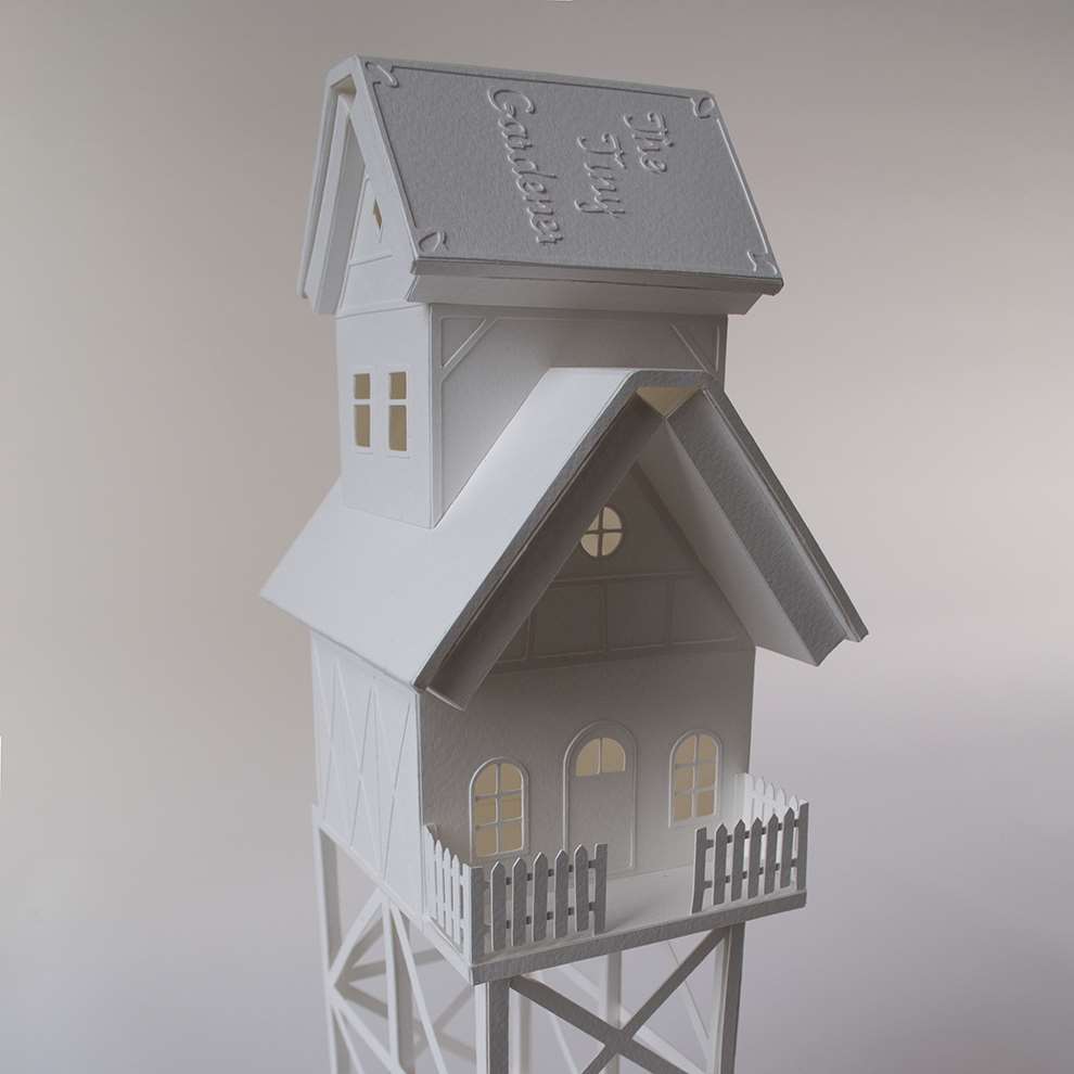 Vera Van Wolferen, Crafted intricate paper sculpture of a magical house with a book on its roof.
